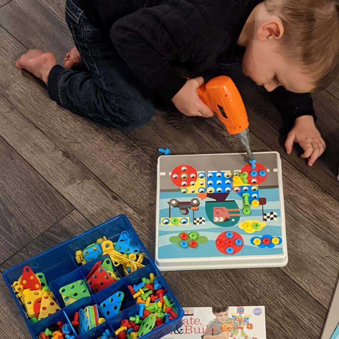 Boy playing with Create, Drill and Build STEM kit from Discovery Toys