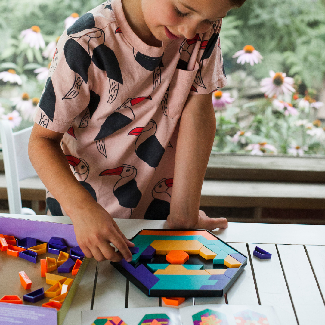 Boy playing with Discovery Toys' Mosaic Mysteries Puzzle